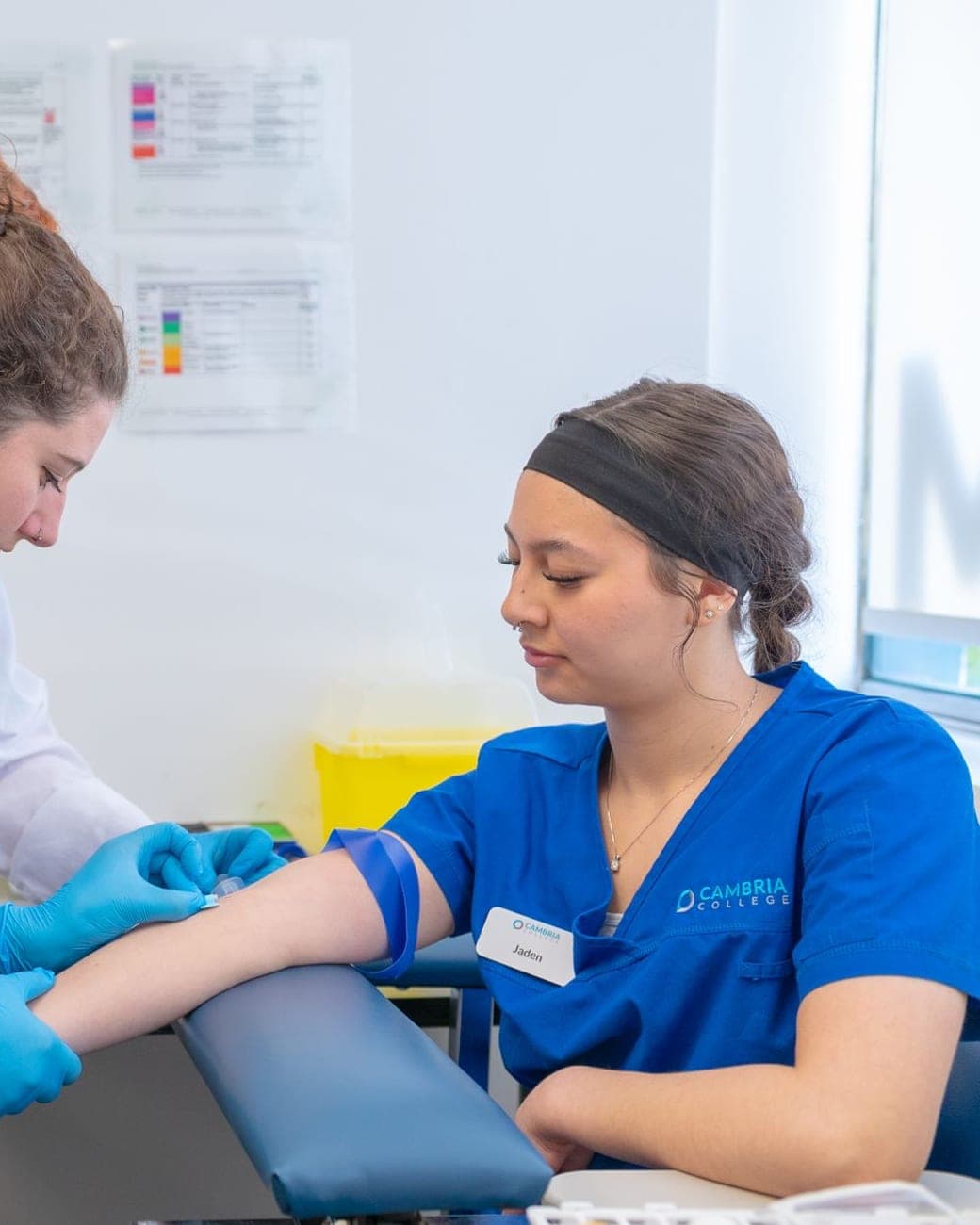 A nurse taking a blood sample from a patient's arm
